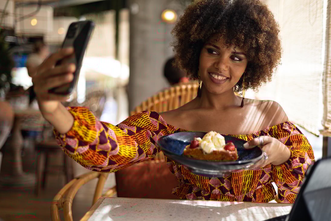 Young African content creator photographing a dessert for social networks